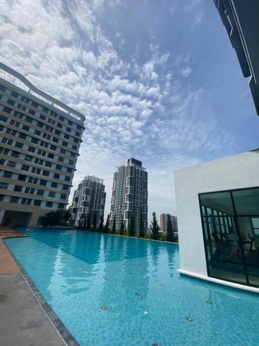 a large swimming pool in a city with tall buildings at Aura Homestay - Edusphere Suites in Cyberjaya