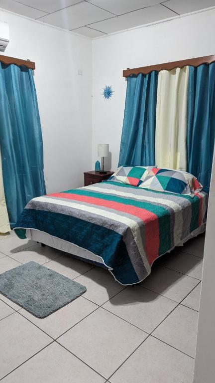 a bedroom with a bed with blue curtains at La casa de don Matilde in San Pedro Sula