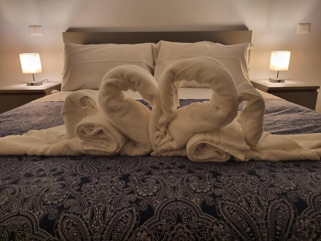 two swans are sitting on a bed with towels at B&B Estia Domus in Pompei
