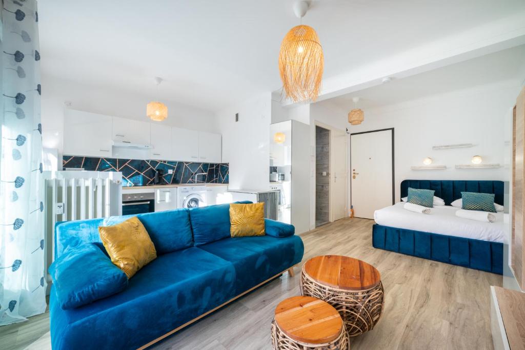 a living room with a blue couch and a table at CASTEL 2 Studio au centre ville de Menton Gare SNCF in Menton
