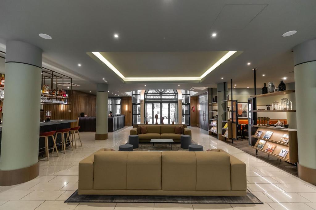 a large lobby with a couch and a bar at Adina Apartment Hotel Budapest in Budapest