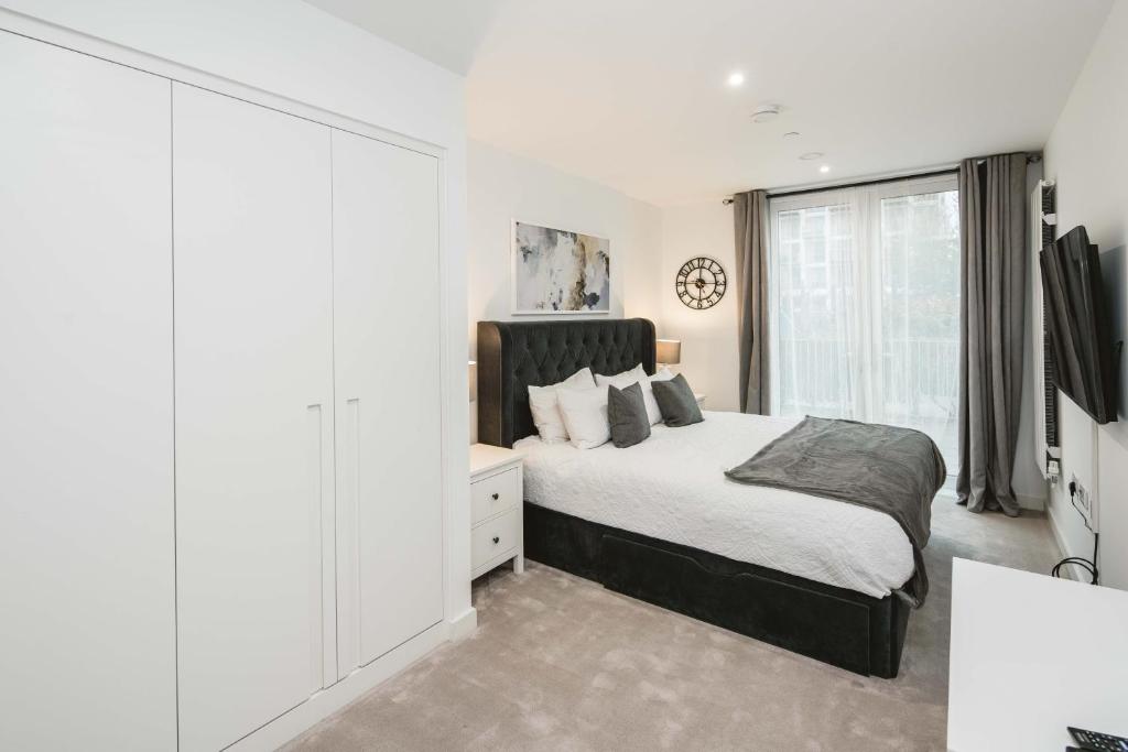 Habitación blanca con cama y ventana en Stunning 3-Bed Apartment in London, en Londres