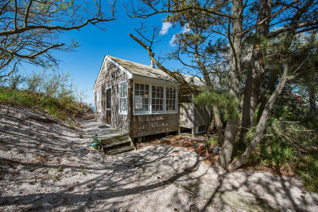 a house on the beach with trees at Beachfront Romance: Rustic Home w/ Private Beach in Wading River