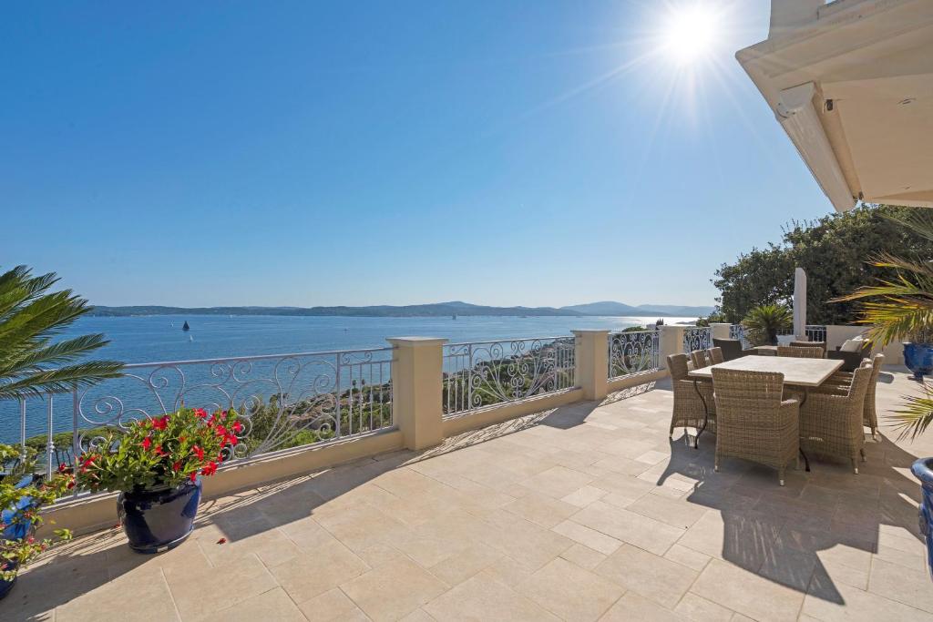 un patio con mesa, sillas y el océano en Villa Evasion, en Sainte-Maxime