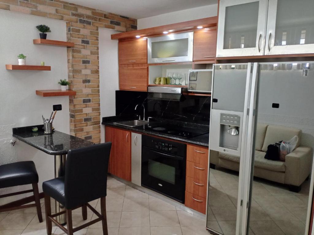a kitchen with a refrigerator and a table in it at Apartamento playero en Lecheria in El Morro de Barcelona
