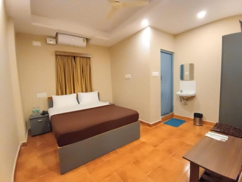 a hotel room with a bed and a bathroom at The Nisarga Residency in Bangalore