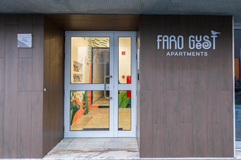 Faro Guest Apartments في فارو: باب امام مبنى عليه لافته