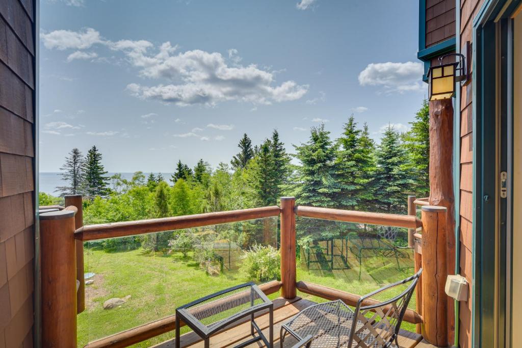 a balcony with two chairs and a view of trees at Tofte Tranquility Lakefront Townhome with Balcony! in Tofte