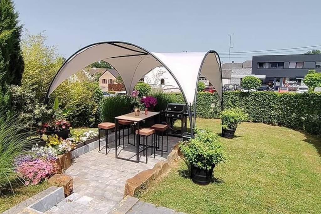 un patio con tavolo e sedie in giardino di Le charme des pierres a Ohey