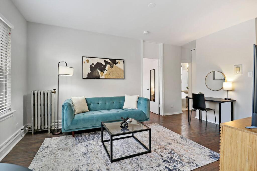 sala de estar con sofá azul y mesa en 1BR Lively and Fully Furnished Apartment - Kenwood 5408, en Chicago