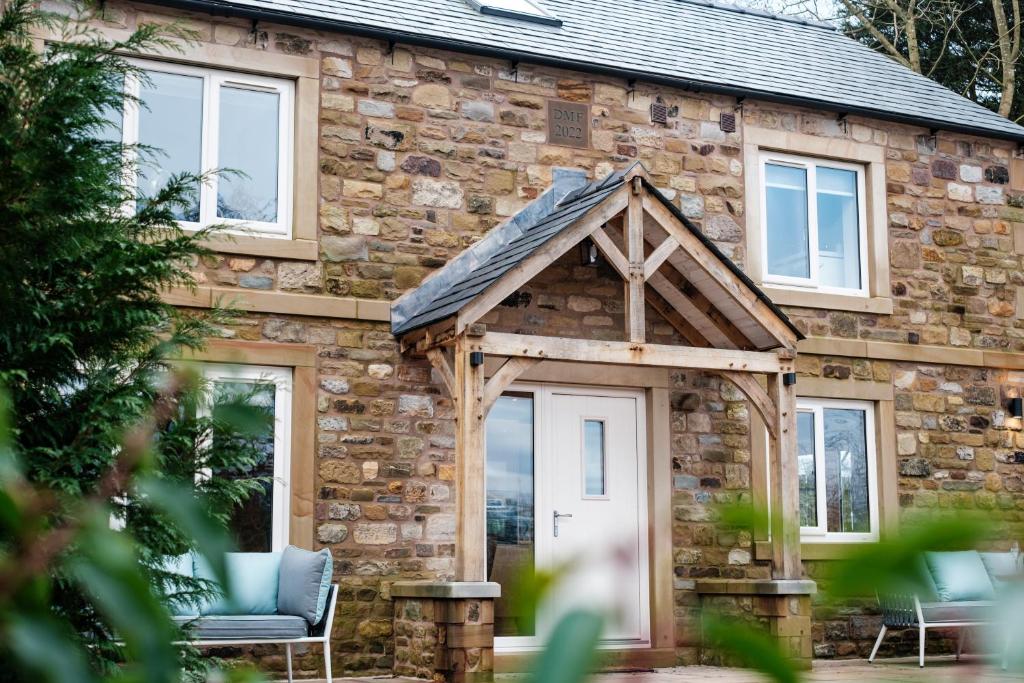 Bramley Brook Cottage 5* Luxury في وهلي: بيت حجري مع شرفة