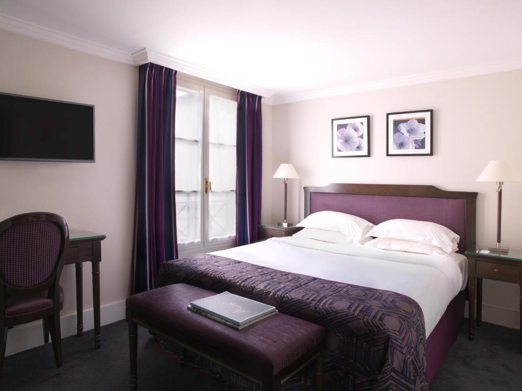 a hotel room with a large bed and a window at Hotel Royal Saint Honore Paris Louvre in Paris