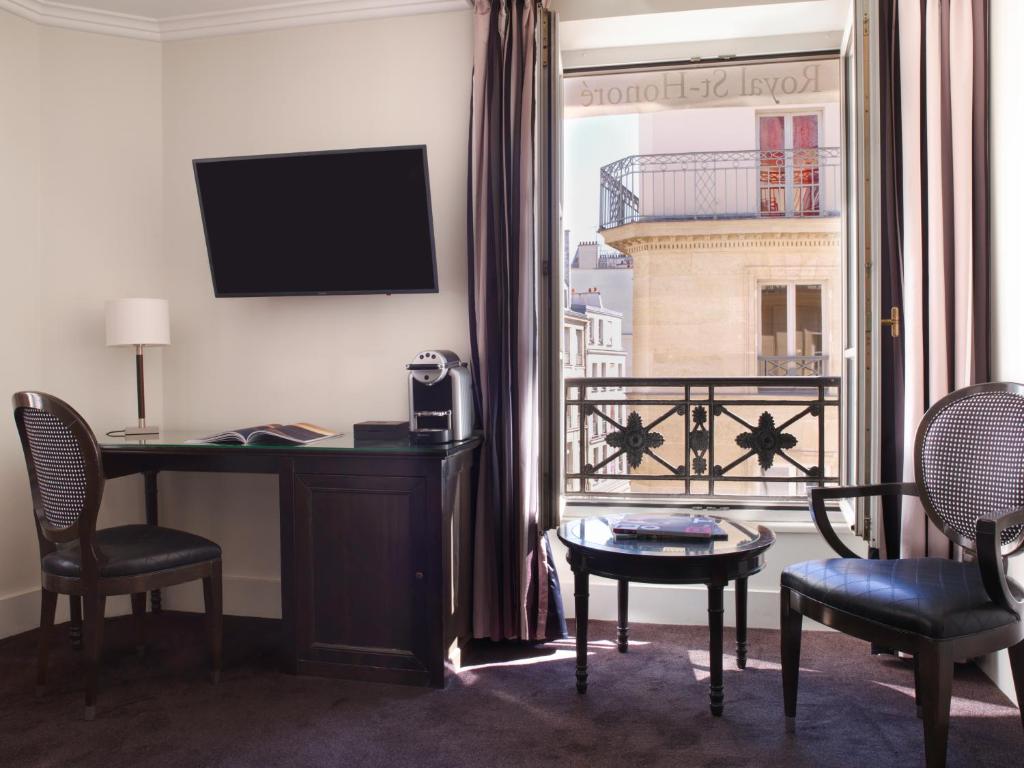a hotel room with a desk and a window at Hotel Royal Saint Honore Paris Louvre in Paris