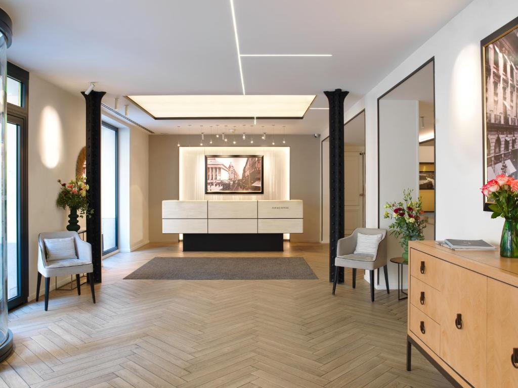 a large lobby with a white dresser and chairs at Hotel Royal Saint Honore Paris Louvre in Paris