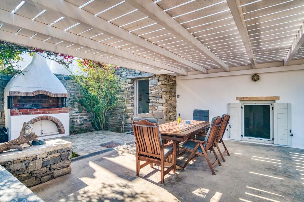 a patio with a table and chairs and a fireplace at Great house w/ BBQ in Paros in Santa Maria
