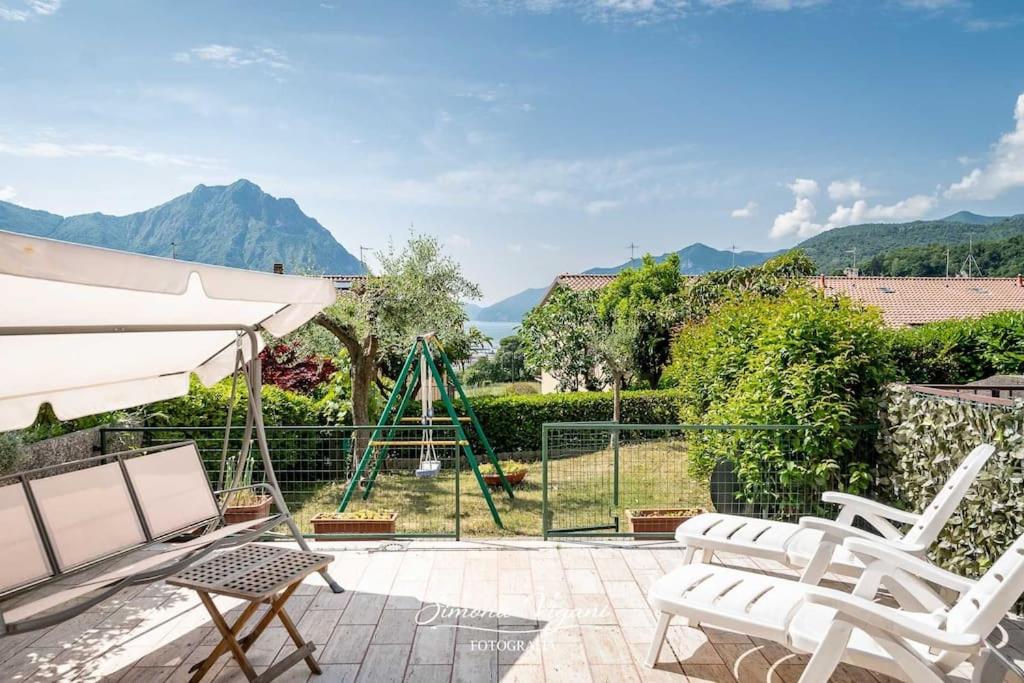 eine Terrasse mit zwei weißen Stühlen und einer Schaukel in der Unterkunft Letizia Lake House - Lovere in Lovere