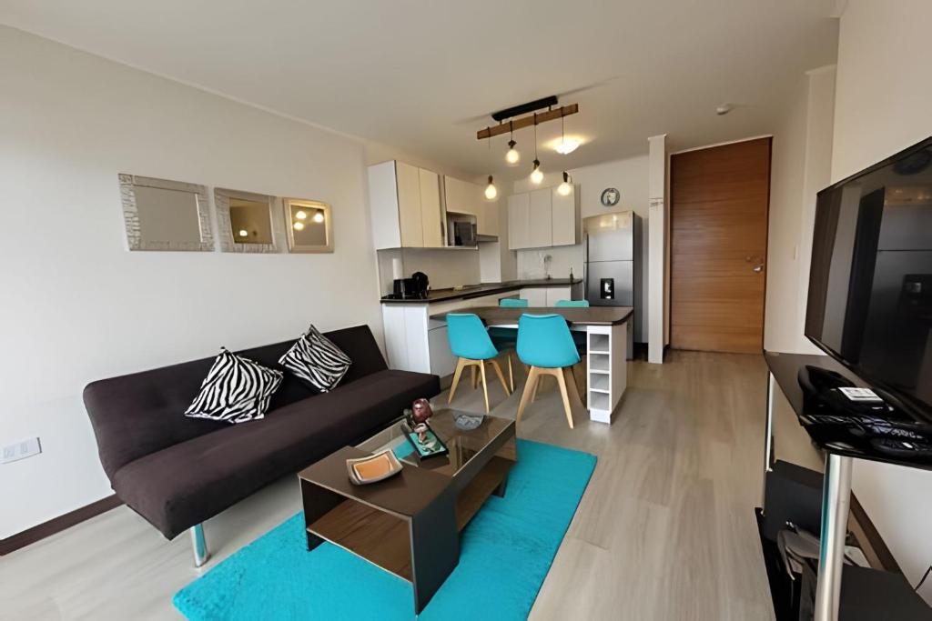 a living room with a couch and a kitchen at Condominio Pacífico 2800 in La Serena