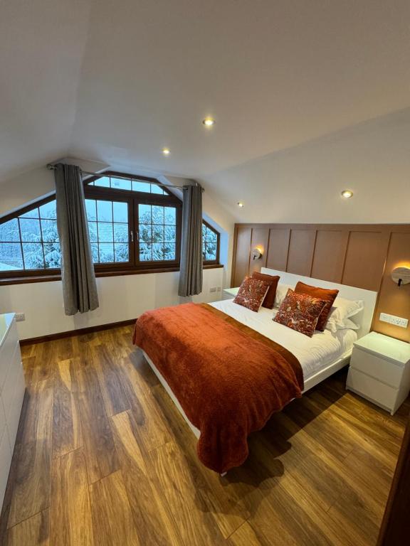 a large bedroom with a large bed and windows at 1 Sheraton Apartments in Fort William