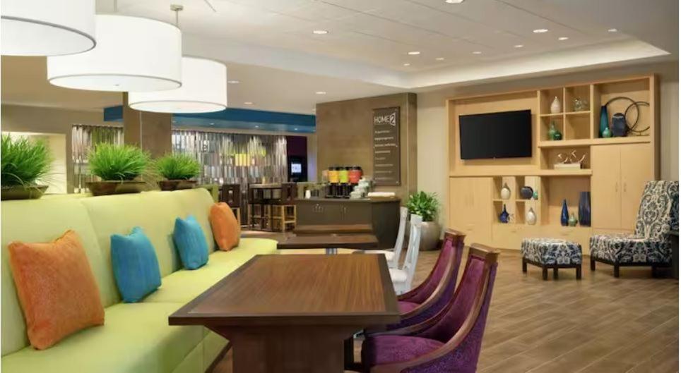 a hotel lobby with a table and chairs at Home2 Suites By Hilton Forrest City in Forrest City