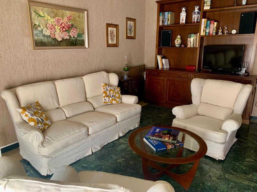 Sala de estar con 2 sofás blancos y mesa de centro en Casa Cele centro città vista mare, en Ventimiglia