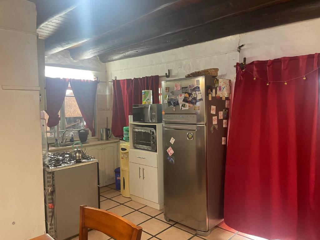 a kitchen with a refrigerator and a red curtain at Fabiana in Gualeguaychú