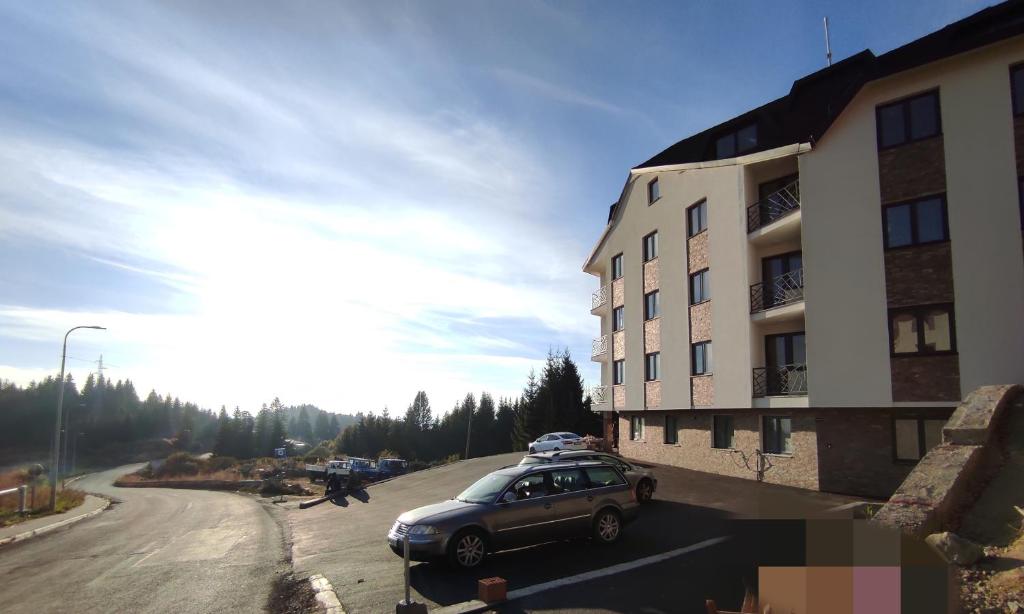 a car parked on a street next to a building at Apartman Nesic kop in Kopaonik