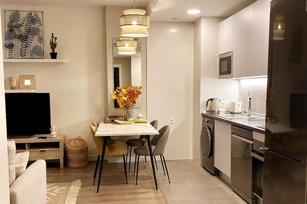cocina con mesa y cocina pequeña con comedor en Nuevo Moderno Apartamento de Lujo, en Sevilla