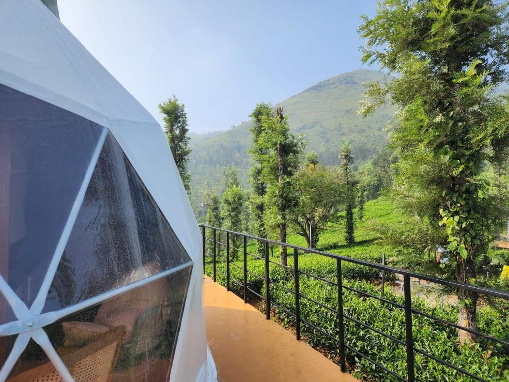 uma vista para uma varanda com um guarda-chuva em Vythiri Tea valley em Vythiri