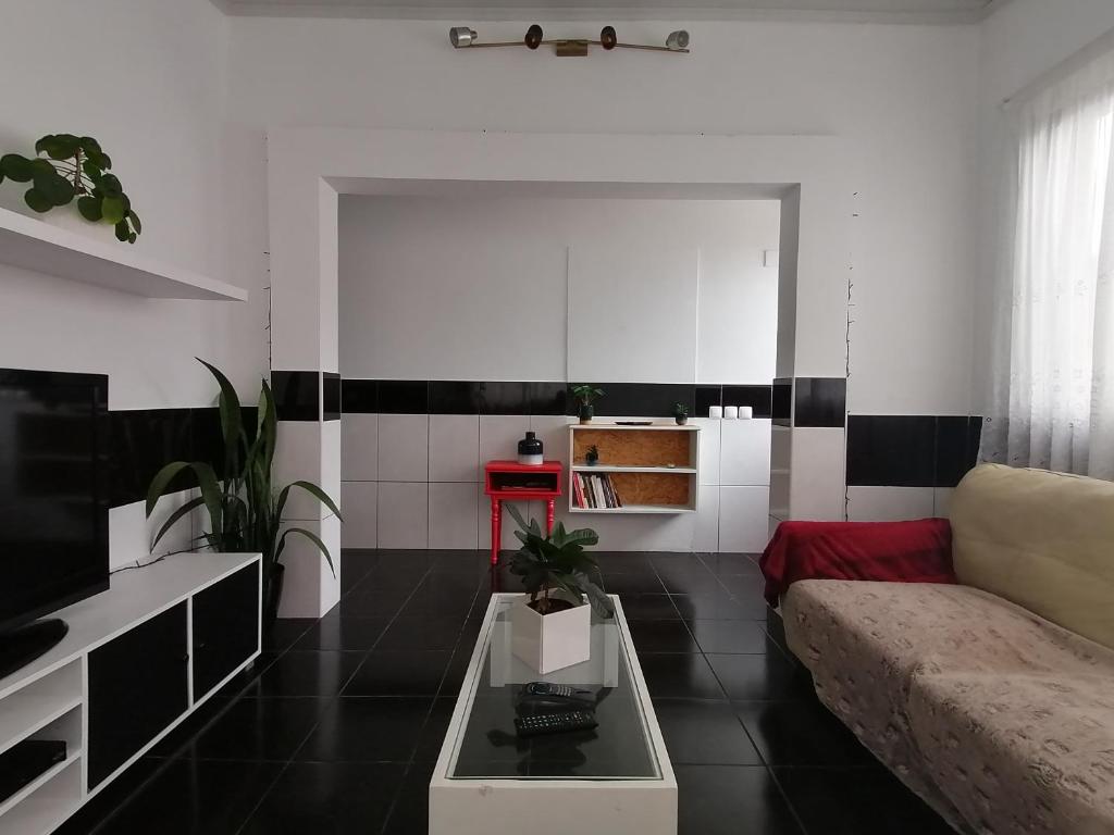 ein Wohnzimmer mit einem Sofa und einem Tisch in der Unterkunft Kanela Guest house in Machico