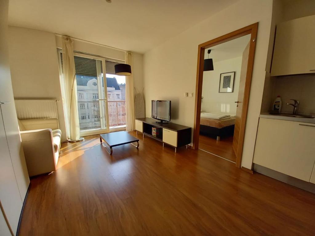ein Wohnzimmer mit einem TV und Holzböden in der Unterkunft Joker in Budapest