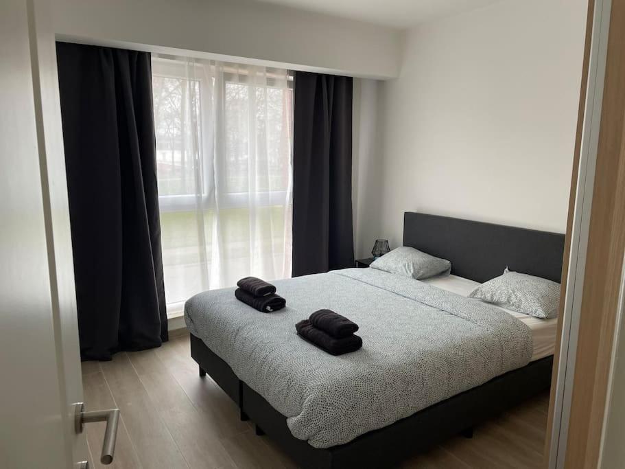 a bedroom with a bed with two towels on it at Appartement Brussels Airport in Machelen