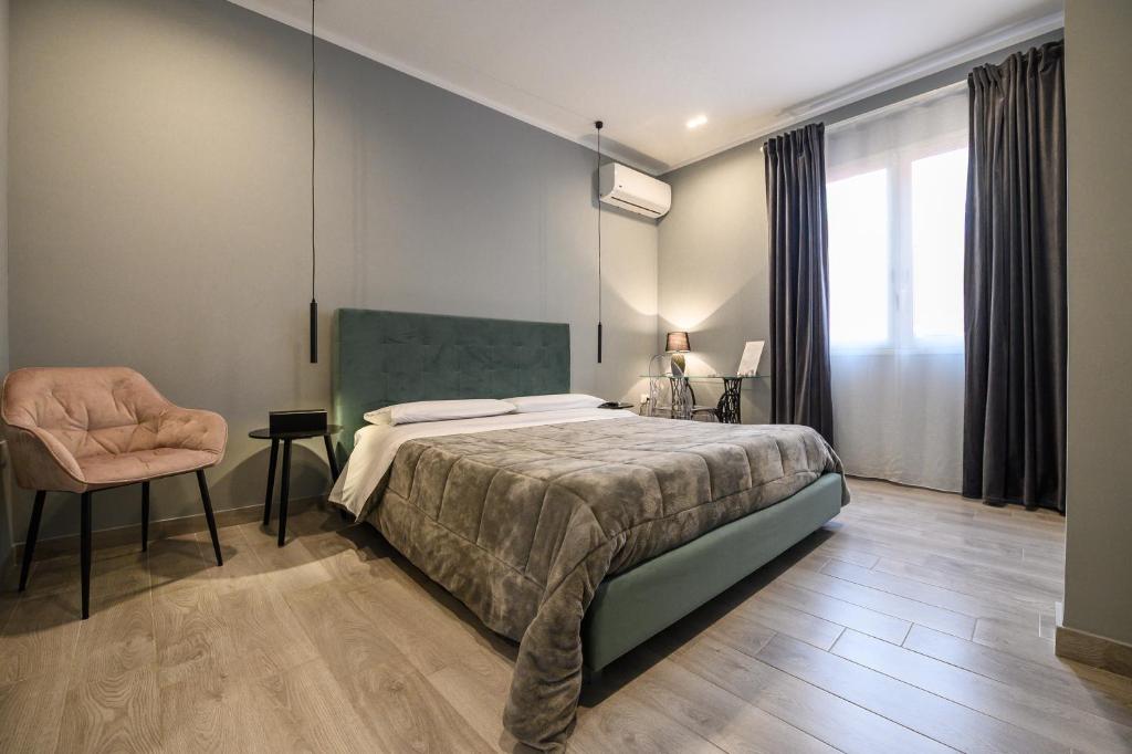 a bedroom with a bed and a chair at B&B Il Cortile Degli Artisti in Marsala