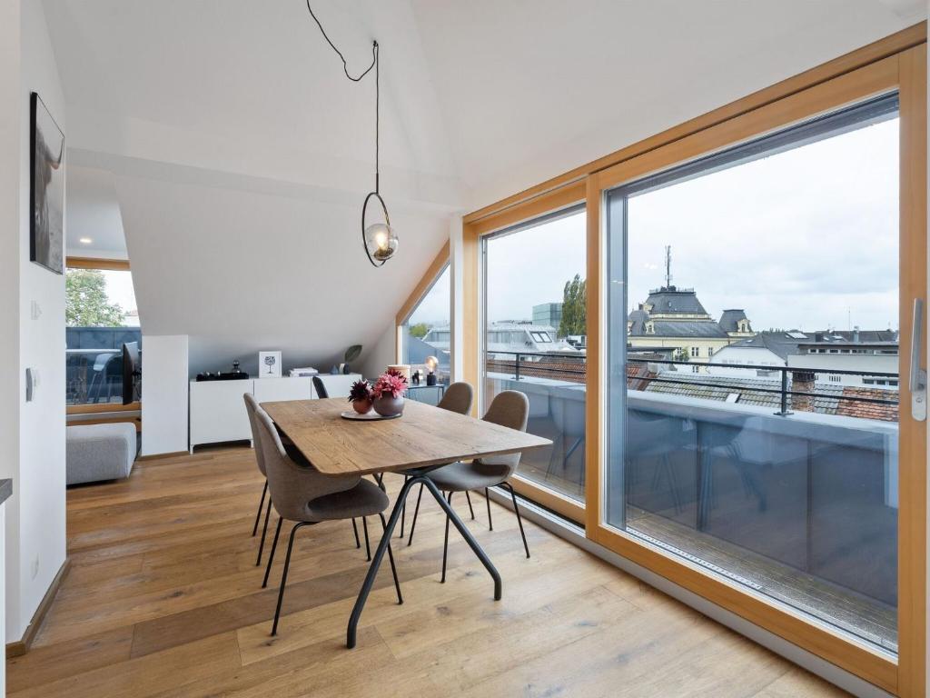 ein Esszimmer mit einem Tisch und einem großen Fenster in der Unterkunft Traumhafte Stadtwohnung mit Blick auf den Bodensee in Bregenz