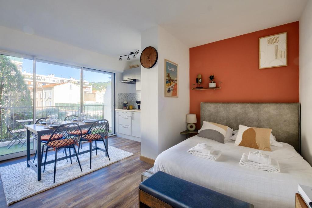 une chambre avec un lit et une table avec des chaises dans l'établissement Magnifique studio avec terrasse au cœur de Cannes, à Cannes