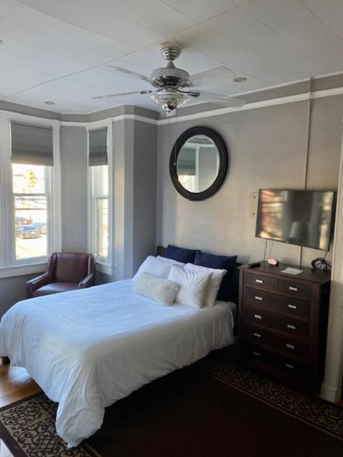 a bedroom with a bed and a television and a chair at Travelers Delight APT with Amenities, King St 1 mi in Alexandria