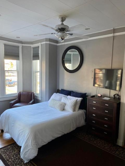 um quarto com uma cama, uma televisão e uma cadeira em Travelers Delight APT with Amenities, King St 1 mi em Alexandria