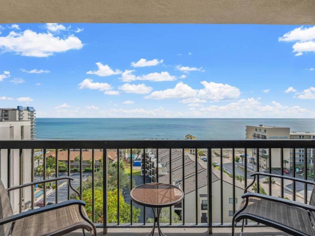 a balcony with chairs and a table and the ocean at Ocean View Condo, Beach Access, Pools, Views in Myrtle Beach