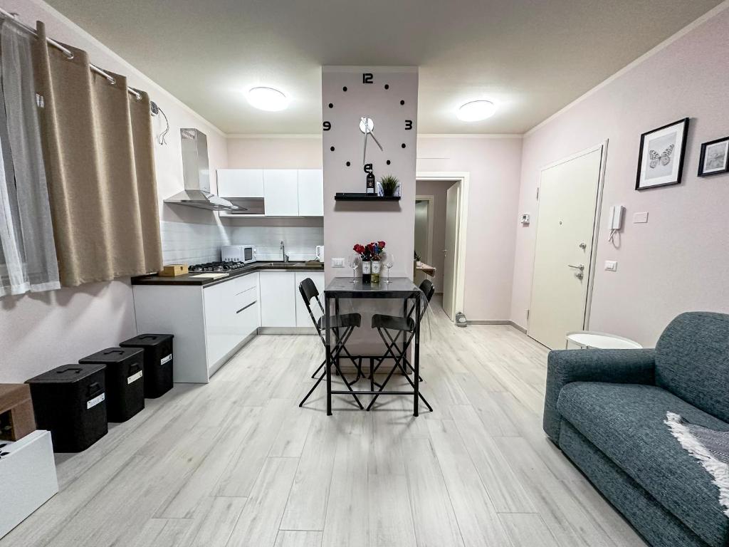 eine Küche und ein Wohnzimmer mit einem Tisch und einem Sofa in der Unterkunft La Rosa dei Venti con parcheggio e ampio giardino in centro in Lucca