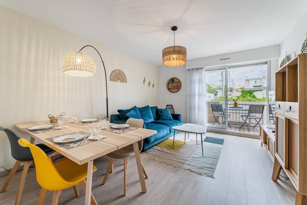 un salon avec une table et un canapé bleu dans l'établissement Beau T2 avec terrasse proche des plages, à Marseille