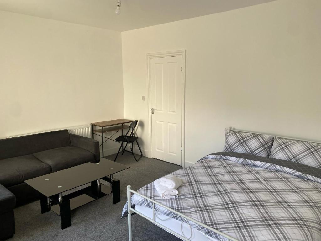 een woonkamer met een bed en een bank bij SWEET DREAMS 2 in Luton