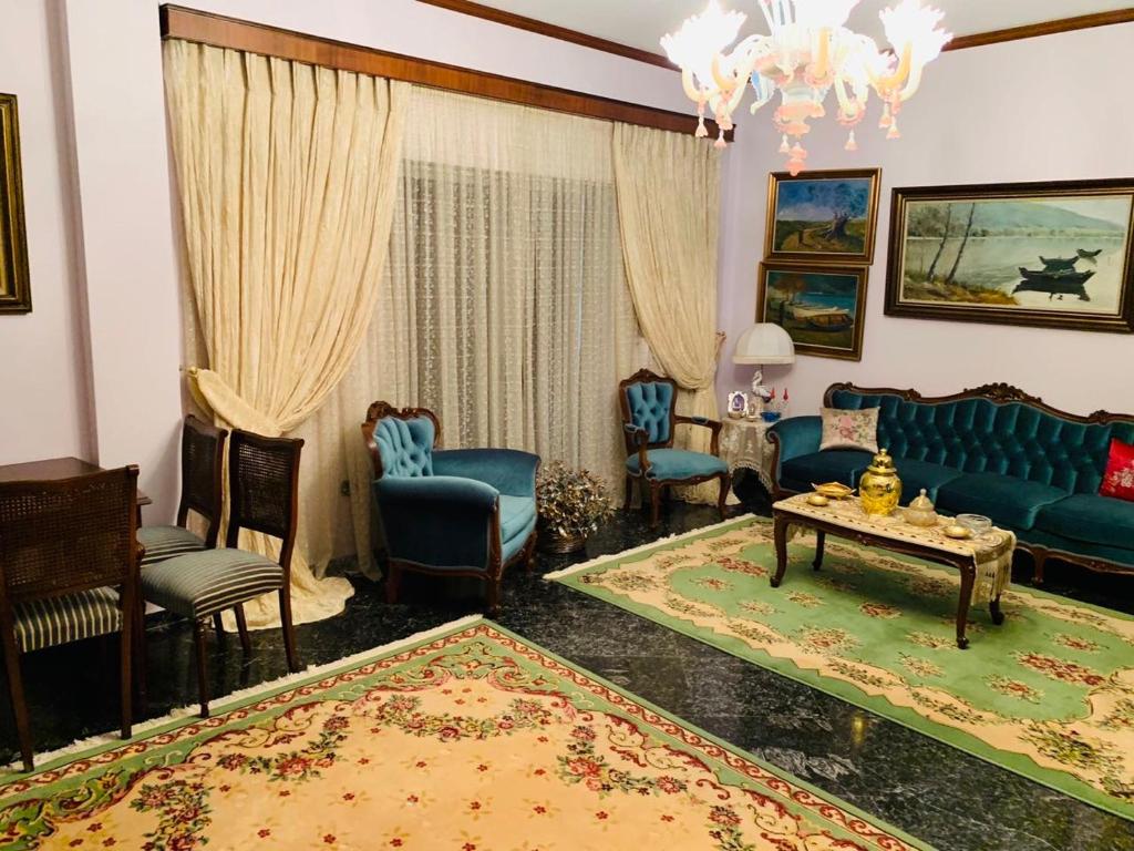 ein Wohnzimmer mit einem blauen Sofa und Stühlen in der Unterkunft House Mario’s airport 2 in Spáta