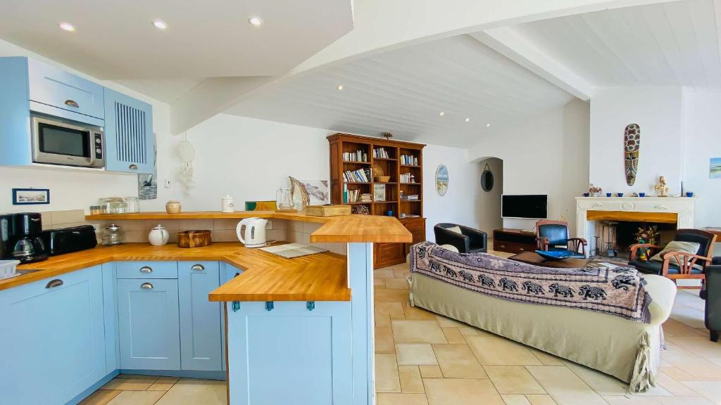 kuchnia z niebieskimi szafkami i salon w obiekcie Villa à proximité de la plage et des commerces w mieście La Couarde-sur-Mer