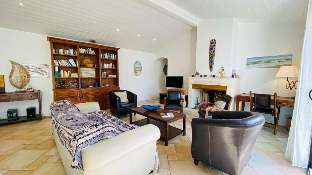 salon z dwiema kanapami i kominkiem w obiekcie Villa à proximité de la plage et des commerces w mieście La Couarde-sur-Mer