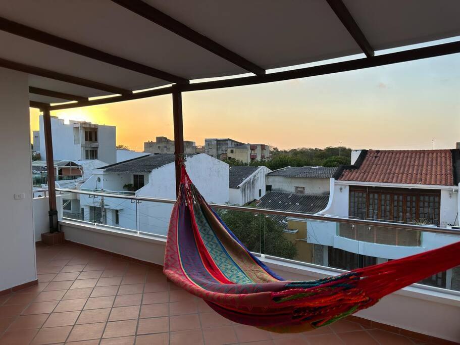 een hangmat op een balkon met uitzicht op de stad bij Apartamento Victoria in Puerto Colombia