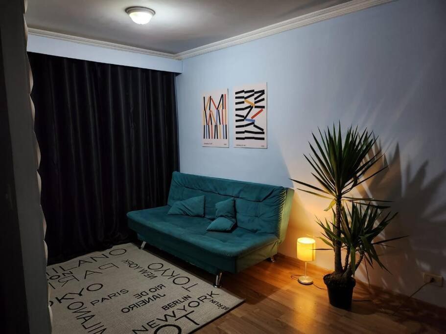 a living room with a blue couch and a plant at Apê perto Alphaville in Osasco