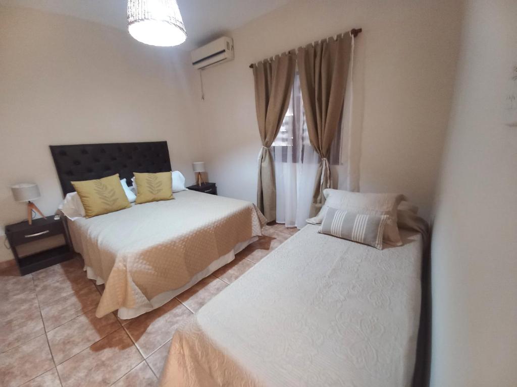 sypialnia z 2 łóżkami i oknem w obiekcie Departamento Montevideana w mieście Villa Mercedes