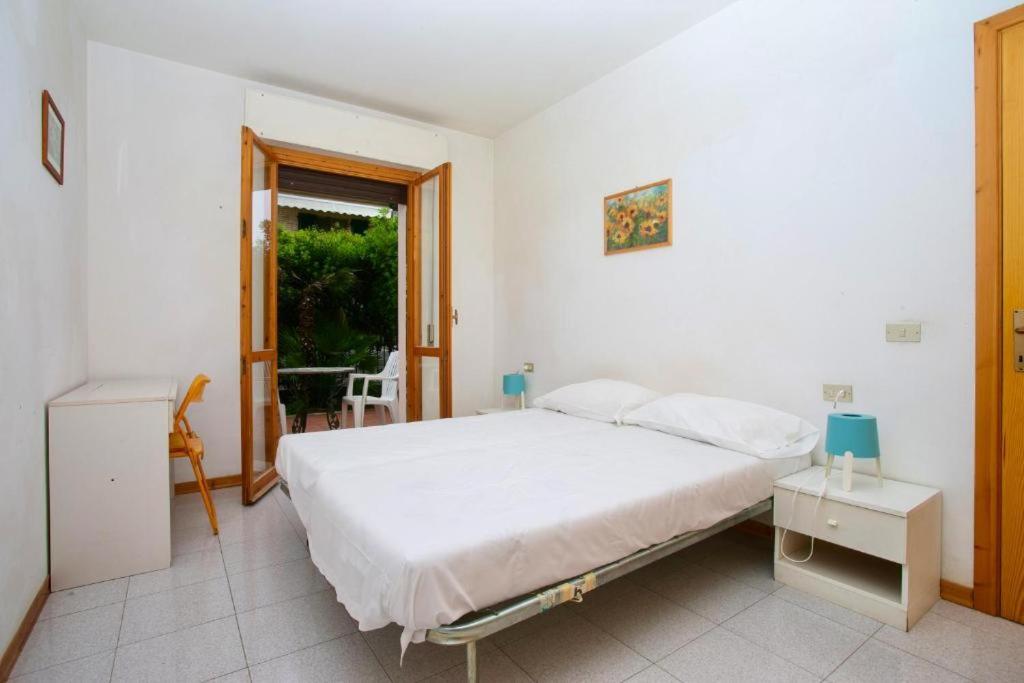 1 dormitorio con cama, mesa y ventana en Bilocale con giardino al centro a Sirolo - S075 en Sirolo