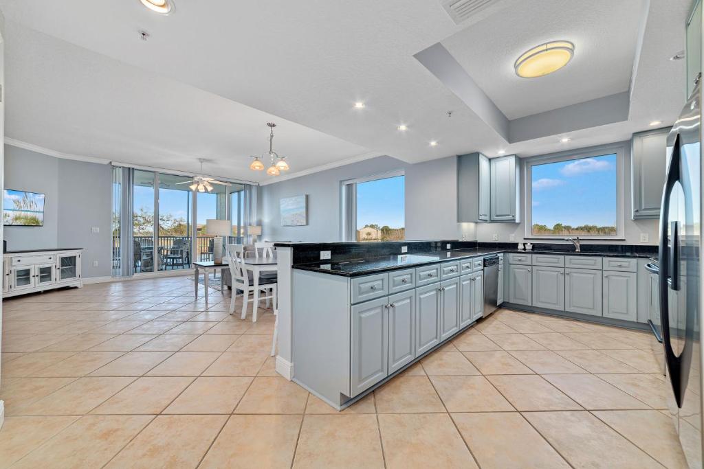une cuisine avec des placards gris et une salle à manger dans l'établissement San Andres Unit A205 at Lost Key Golf & Beach Club, à Pensacola