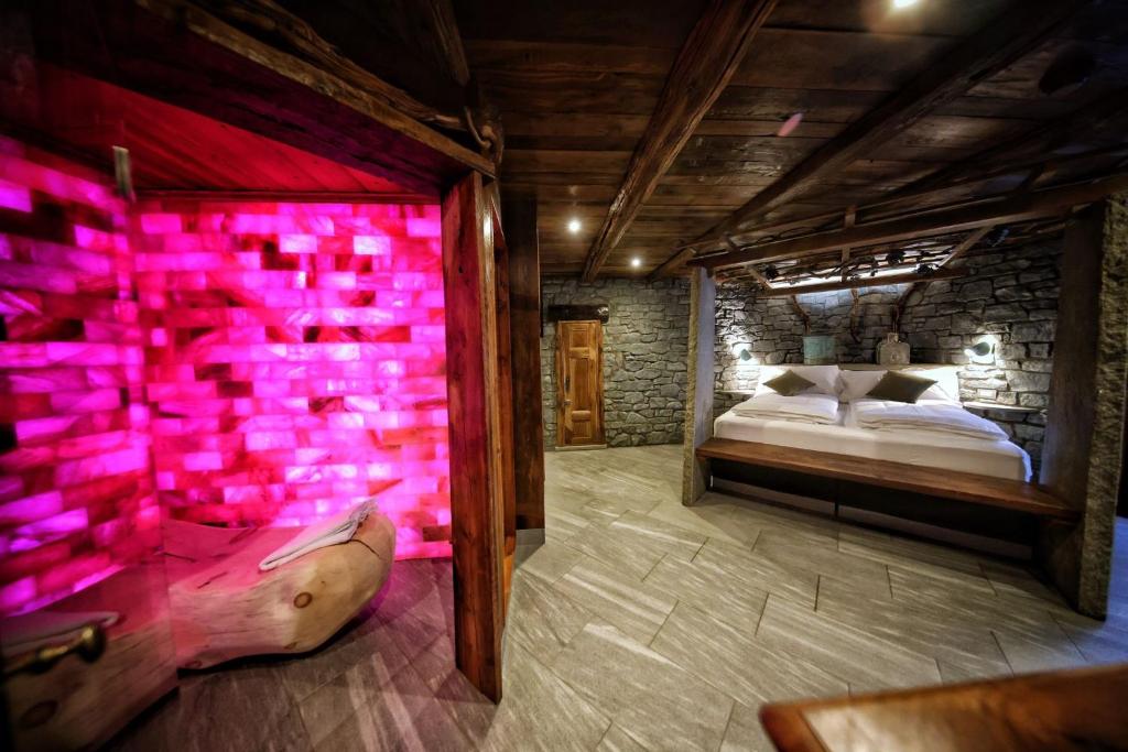 a bedroom with a bed with pink lights on the wall at Café Quinson Relais de Charme in Morgex
