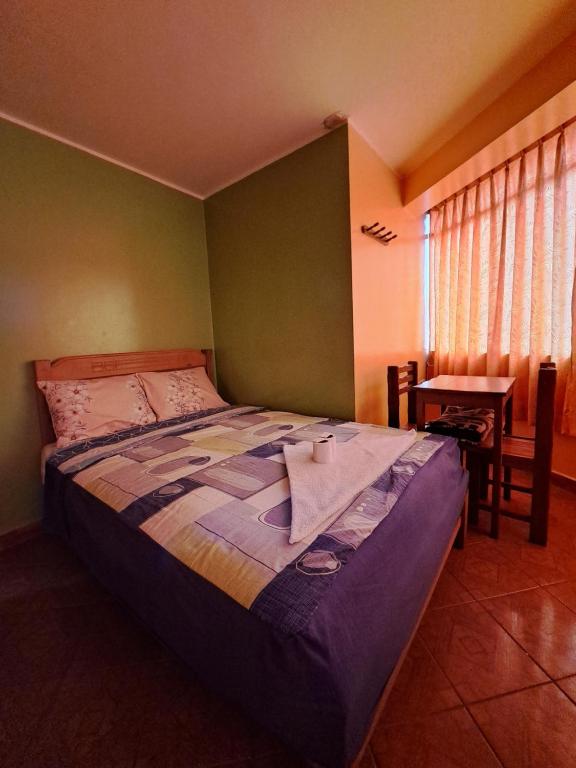 een slaapkamer met een bed, een tafel en een raam bij Hospedaje Escorpio in Lima